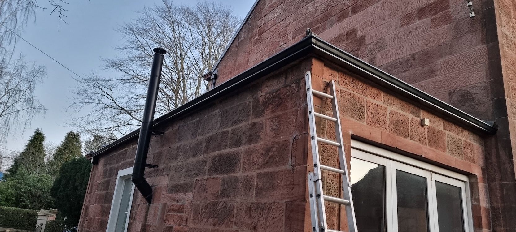 Seamless gutter fitted to a red sandstone house